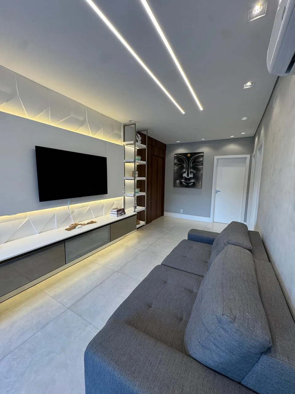 Sala de estar com sofá, TV e vista da janela